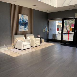 A modern lobby with comfortable seating and contemporary artwork, illuminated by natural light.