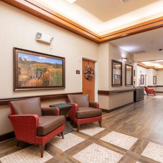 A well-lit hallway with comfortable seating and artwork on the walls.