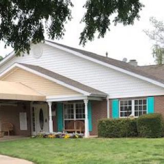 A cozy residential house with a well-maintained lawn and trees.