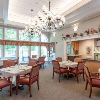 An inviting dining room featuring elegant chandeliers and comfortable seating, bathed in natural light.
