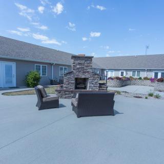 Outdoor patio area with seating and a central fireplace.