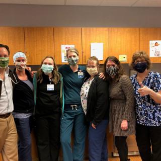 A group of healthcare workers posing together in a hospital setting.