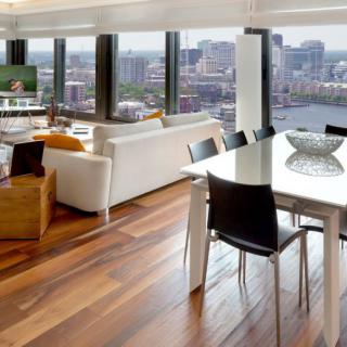 A modern apartment featuring a spacious living room and dining area with large windows overlooking the city skyline.