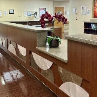 A modern reception desk with decorative elements and a flower arrangement.