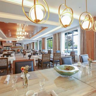 A modern and elegant restaurant interior with warm lighting and stylish chandeliers.