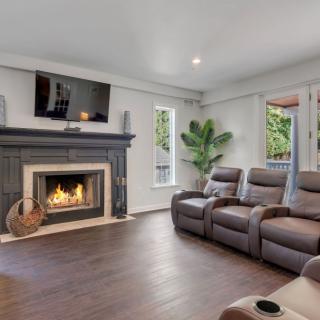 A cozy living room with a fireplace, wall-mounted television, and comfortable recliner chairs.