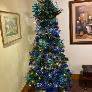 A beautifully decorated Christmas tree adorned in shades of blue with lights, bringing festive cheer to the room.