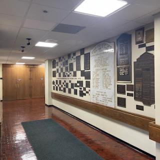 A corridor featuring a wall adorned with various plaques and recognition displays.