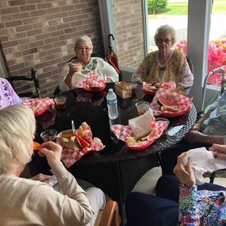 A group of seniors enjoying a meal together at an outdoor table.