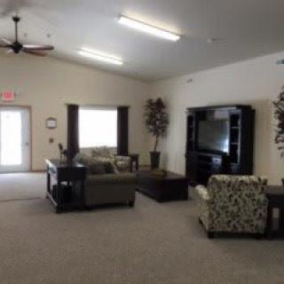 A spacious living room with comfortable seating and a large TV.