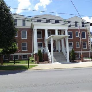 A classic brick building with prominent columns and stairs, showcasing traditional architectural design.