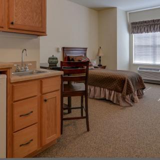 A cozy bedroom with a single bed, desk, and window.