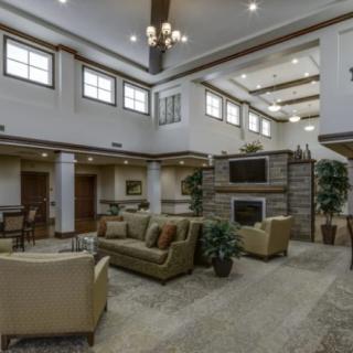 A spacious lobby with comfortable seating, a fireplace, and ample natural light.