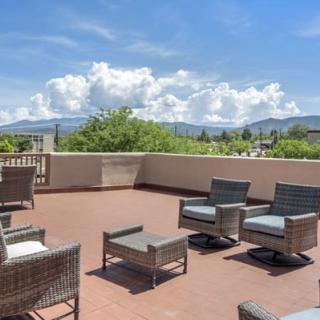 Outdoor patio with wicker furniture and a scenic mountain view under a clear blue sky.