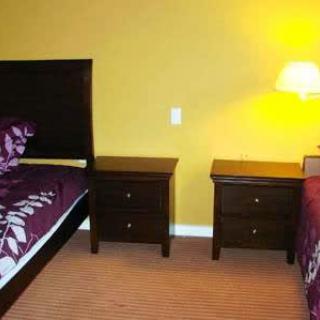 A cozy bedroom with two beds, nightstands, and a lamp.