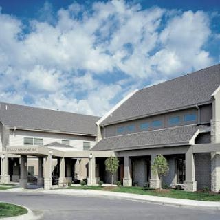 A modern residential building surrounded by a clear sky and fluffy clouds.