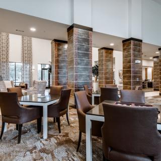 A modern restaurant interior with tables and chairs arranged for dining.