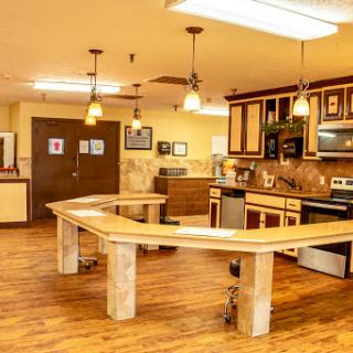 A spacious and well-equipped kitchen featuring modern appliances and a unique curved table design.