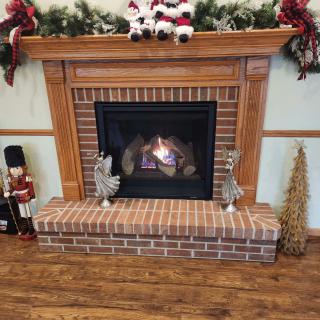 A cozy fireplace adorned with festive holiday decorations, including nutcrackers and greenery.