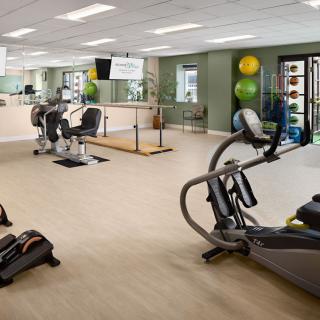 A spacious gym with various exercise equipment, including treadmills and stationary bikes.