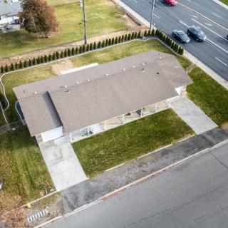 A suburban house with a driveway and well-maintained lawn, viewed from above.