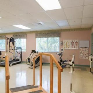 A rehabilitation gym with various exercise equipment and training aids.