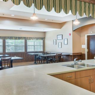 A spacious kitchen and dining area with several tables, chairs, and a large countertop.