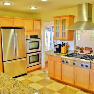 Modern kitchen with stainless steel appliances and wooden cabinetry.