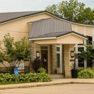 A modern building entrance with well-maintained landscaping and trees.