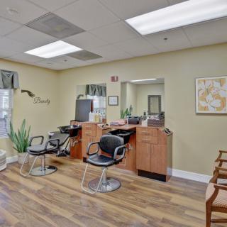An interior view of a hair salon with styling stations and comfortable seating.