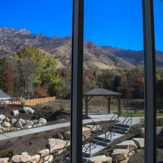 A serene view of mountains and a park from a modern building.