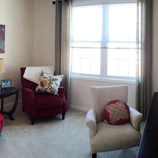 A cozy living room corner with armchairs and a large window letting in natural light.
