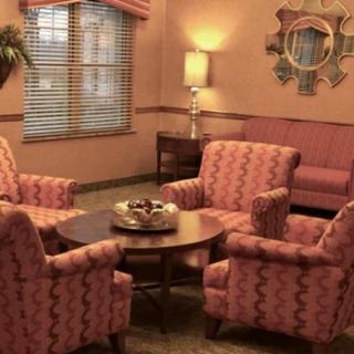 A cozy living room with pink patterned furniture and warm lighting.