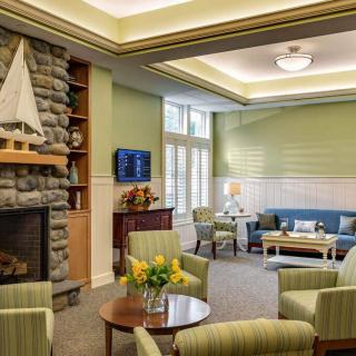 A cozy living room with green walls, a fireplace, and comfortable seating.