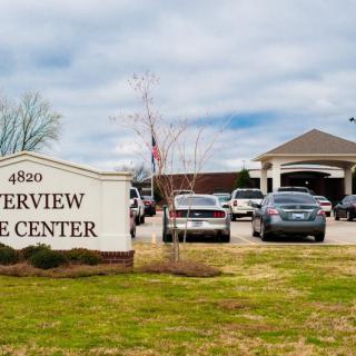 Exterior view of Riverview Care Center with parked cars.