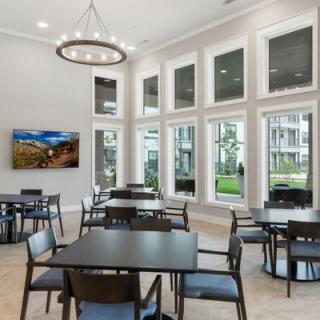 A spacious and modern dining area featuring large windows and elegant furnishings.