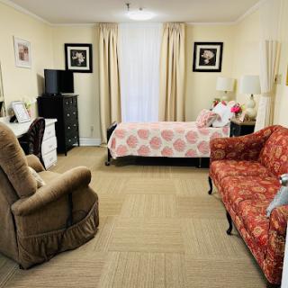 A cozy bedroom featuring a comfortable bed, decorative seating, and warm lighting.