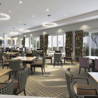 A spacious and modern restaurant interior with neatly arranged tables and chairs.
