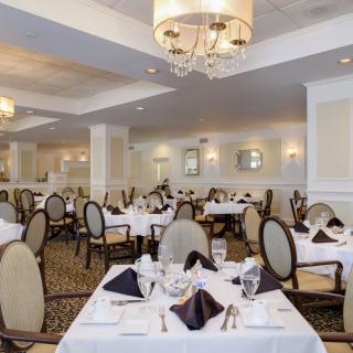 A spacious and elegant dining room with tables set for guests.