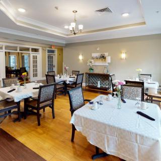 An elegant dining room with neatly arranged tables and chairs, featuring a warm interior design.