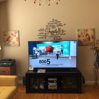 A cozy living room featuring a television with wall decor and artwork.