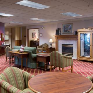 A cozy hotel lobby with comfortable seating, a fireplace, and elegant decor.