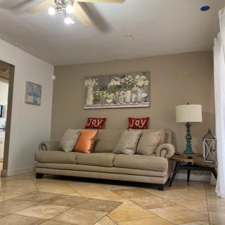 A cozy living room with a beige sofa, decorative cushions, and warm lighting.