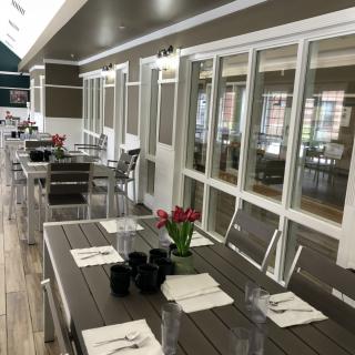 A modern indoor dining area with neatly arranged tables and chairs, adorned with flowers.