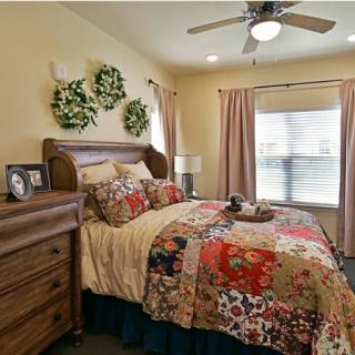 Cozy bedroom with rustic decor and a colorful quilted bedspread.