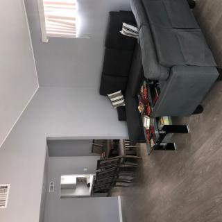 A spacious living room with a grey sofa set and matching decor.