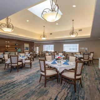 An elegant dining room with beautifully set tables, chandeliers, and tasteful interior decor.