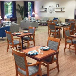 An empty dining area with neatly arranged tables and chairs, featuring a cozy interior design.