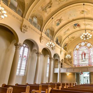 A beautifully adorned church interior with stained glass and ornate ceiling designs.