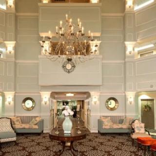 A luxurious hotel lobby featuring an ornate chandelier and elegant furnishings.